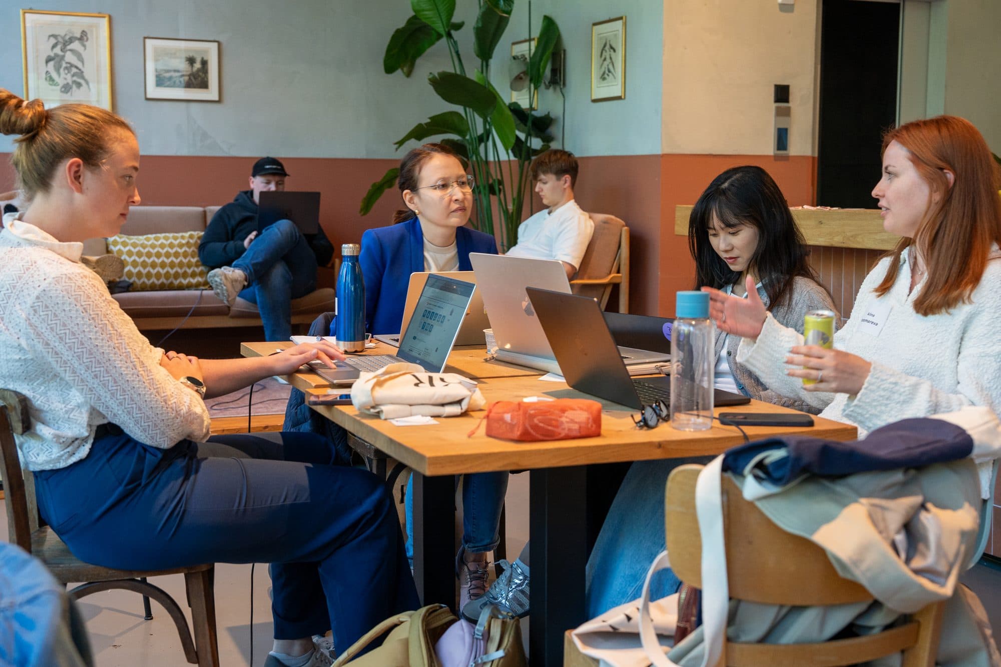 A team discussing their project around a table of laptops